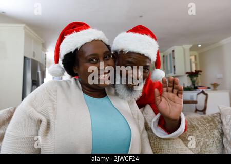 Ritratto di una coppia africana americana senior sorridente e indossante cappelli santa Foto Stock
