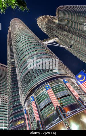 Ritratto, primo piano delle Torri Petronas con la bandiera malese in primo piano, Kuala Lumpur, Malesia Foto Stock