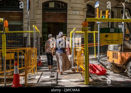 Barcellona, Spagna. 04th Set, 2022. Durante i lavori urbani si vedono pedoni che attraversano passaggi stretti. Il comune di Barcellona inizia i lavori di quello che è il progetto urbano centrale del governo del sindaco Ada Colau, consistente nella riconversione di una delle strade principali dell'Eixample, la strada del Consell de Cent, e delle sue adiacenti in assi verdi e isole pedonali. Credit: SOPA Images Limited/Alamy Live News Foto Stock