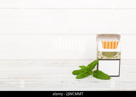 Confezione di sigarette mentolo e menta fresca su tavola colorata, sigarette mentolo vista dall'alto stesa piatta. Foto Stock