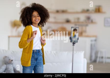 bella ragazza pre-teen afroamericana che registra video mentre balla Foto Stock