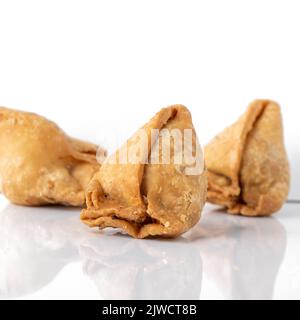 Samsa o samosa su sfondo bianco. Un cibo indiano tradizionale. Foto Stock