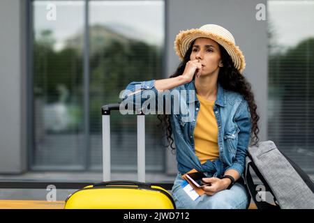 Giovane donna pensiva turista seduta su panca all'aperto Foto Stock