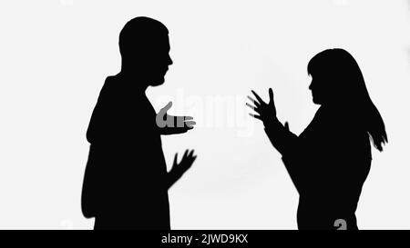 silhouette di uomo e donna in lite e gesture isolate sul bianco Foto Stock