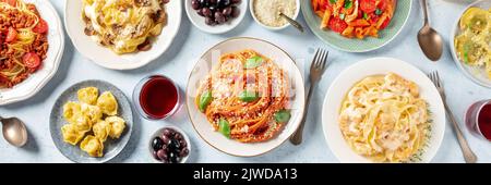 Panorama della pasta. Assortimento di pasta italiana, con spaghetti alla bolognese, pasta di pesce, penne con pollo, tortellini, ravioli e altri, piatto sopra la testa di stendere shot con vino Foto Stock