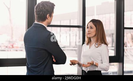 donna sorpresa e positiva che parla con il datore di lavoro durante il colloquio di lavoro, immagine di riserva Foto Stock