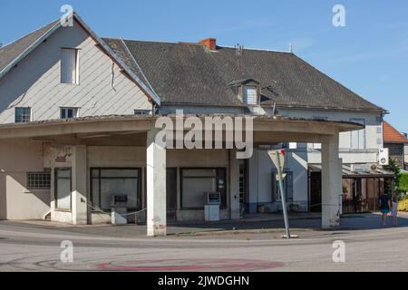 Un vecchio distributore di benzina fuori servizio si trova all'estremità di una rotatoria. C'è una sola pompa per il Super e una pompa per il diesel. Foto Stock