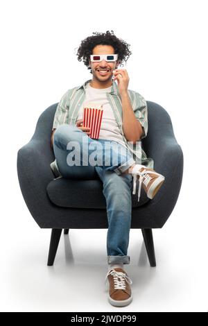 uomo in 3d bicchieri mangiare popcorn seduto in sedia Foto Stock