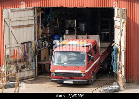 Vecchio servizio di garage arrugginito con auto all'interno Foto Stock