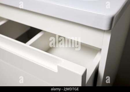 Soluzione per posizionare utensili da cucina in cucina moderna - orizzontale scorrevole estraibile scaffali cassetto in plastica stoccaggio con maniglia closeup in armadio f Foto Stock