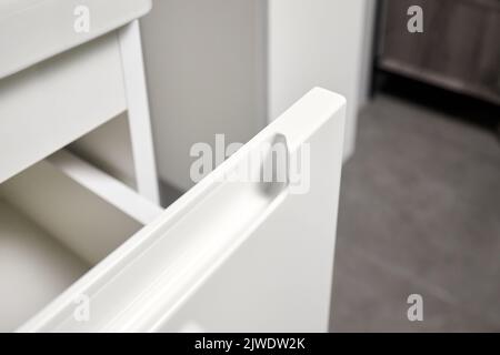 Soluzione per posizionare utensili da cucina in cucina moderna - orizzontale scorrevole estraibile scaffali cassetto in plastica stoccaggio con maniglia closeup in armadio Foto Stock