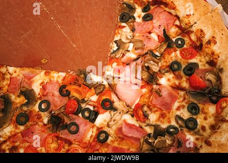 Pizza capriciosa con crosta di formaggio farcito in pizzeria, primo piano Foto Stock