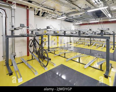 Deposito biciclette nel seminterrato. 50 Eastbourne Terrace, Londra, Regno Unito. Architetto: Sheppard Robson, 2021. Foto Stock