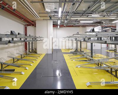 Deposito biciclette nel seminterrato. 50 Eastbourne Terrace, Londra, Regno Unito. Architetto: Sheppard Robson, 2021. Foto Stock