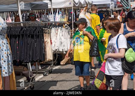 Le persone che indossano camicie e bandiere brasiliane godono di una fiera di strada sulla Sesta Avenue in sostituzione della festa brasiliana a New York. Per il terzo anno consecutivo, il BR Day New York, il più grande partito brasiliano al di fuori del Brasile, non si svolge. João de Matos, presidente del BR Day NY, afferma che l'evento a cui hanno partecipato 1,5 milioni di persone è stato sospeso a causa di una combinazione di fattori, tra cui il recente scoppio di monkeypox a New York; recenti manifestazioni a causa delle elezioni presidenziali in Brasile il prossimo ottobre; e questioni logistiche e di trasporto aereo. (Foto di Ron Adar/SOPA Images Foto Stock