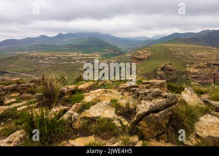 Le lontane Blue Mountains della catena montuosa Drakensberg, coperte da una coperta di nubi piovose basse, come si vede dalla cima del contrafforte Brandwag Foto Stock