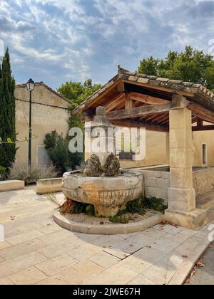 Fontana d'acqua e lavatoio pubblico tradizionale (lavoir) nel centro storico del villaggio, Maussane-les-Alpilles, Bocche del Rodano, Provenza-Alpi-Costa Azzurra, Francia Foto Stock