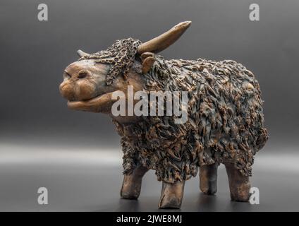 Dettaglio di una figurina di mucca scozzese di razza highland rossa fatta a mano (Bò Ghàidhealach; Hielan coo) con corna complete Foto Stock