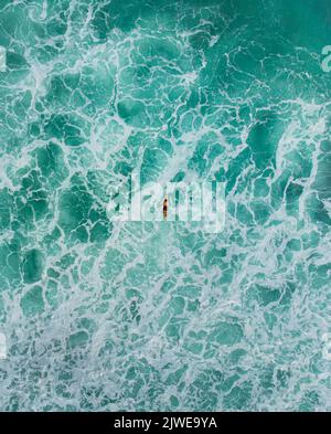 Vista aerea del drone di uomo su una tavola da surf in mare surf, Nias Island, Sumatra settentrionale, Indonesia Foto Stock