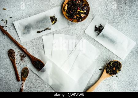 Vista dall'alto di cucchiai di legno con tè assortiti e bustine di tè monouso Foto Stock