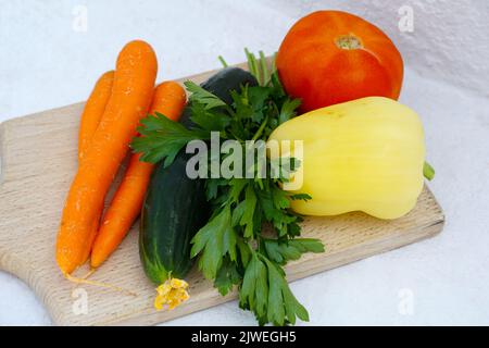 Un mucchio di verdure fresche di coltivazione biologica, carota, cetriolo, foglia di prezzemolo, pepe giallo e pomodoro Foto Stock