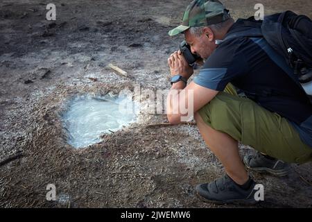 L'escursionista visita la caldera, un piccolo cratere circolare con una palude di acque sulfuree, testimonianza dell'antica presenza di un vulcano. Foto Stock