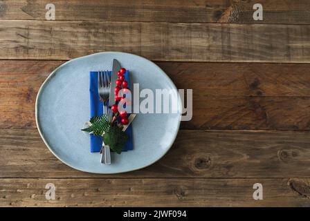 Piatto rustico con decorazioni natalizie all'interno su sfondo di legno. Spazio di copia. Foto Stock