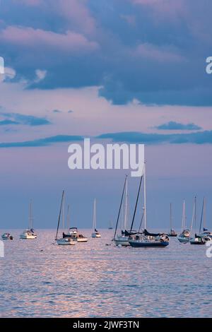 Beverly Harbor si affaccia sulle nuvole rosa e blu ormeggiate Barche a vela luce del sole rosa sull'acqua Foto Stock