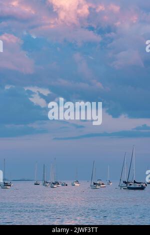 Beverly Harbor si affaccia sulle nuvole rosa e blu ormeggiate Barche a vela luce del sole rosa sull'acqua Foto Stock