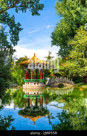 Pagoda cinese e ponte su uno stagno al Giardino della Cina (Chinagarten Zürich), Seefeld, Zurigo, Svizzera Foto Stock