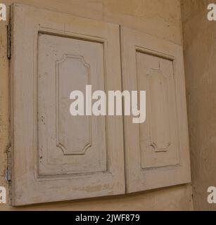 finestre in legno su una casa marrone; ingresso dipinto e porta di una vecchia casa coloniale; finestra marrone chiusa Foto Stock