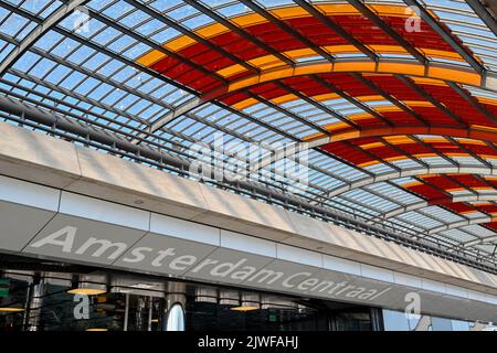 Amsterdam, Paesi Bassi - 2022 agosto: Ingresso alla stazione ferroviaria e degli autobus sotto un tetto curvo ad Amsterdam Centraal. Foto Stock