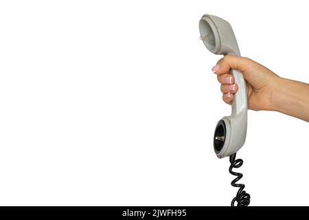 Un vecchio ricevitore telefonico rotto da un telefono fisso in mano a una ragazza su uno sfondo bianco, un telefono rotto, una chiamata Foto Stock