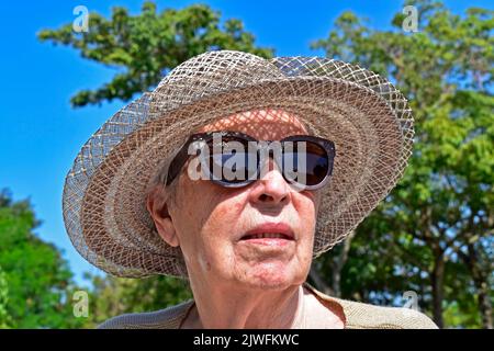 Donna anziana che prende il sole nel parco Foto Stock