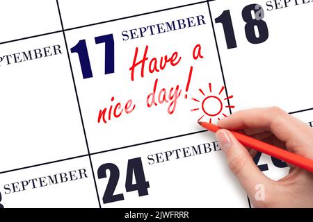 17th° giorno di settembre. La mano che scrive il testo hanno un bel giorno e disegnare il sole sulla data di calendario 17 settembre. Salvare la data. Mese autunnale, Foto Stock