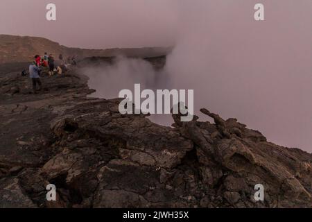 AFAR, ETIOPIA - 26 MARZO 2019: Turisti ai margini del cratere del vulcano Erta Ale nella depressione di Afar, Etiopia Foto Stock