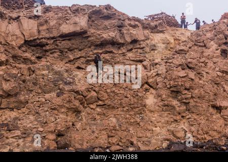 AFAR, ETIOPIA - 26 MARZO 2019: Turisti che si arrampicano dal cratere del vulcano Erta Ale nella depressione di Afar, Etiopia Foto Stock