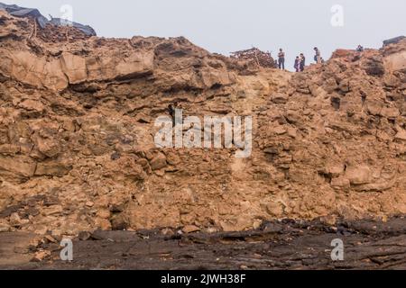 AFAR, ETIOPIA - 26 MARZO 2019: Turisti che si arrampicano dal cratere del vulcano Erta Ale nella depressione di Afar, Etiopia Foto Stock