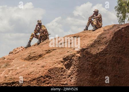 LALIBELA, ETIOPIA - 29 MARZO 2019: Soldati che osservano chiese tagliate nella roccia a Lalibela, Etiopia Foto Stock