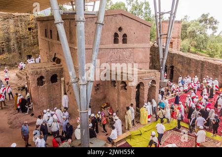 LALIBELA, ETIOPIA - 29 MARZO 2019: Sacerdoti cristiani, devoti e turisti intorno a Bet Maryam, chiesa scavata nella roccia a Lalibela, Etiopia Foto Stock