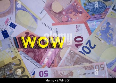 WOW parola con soldi. Sfondo di valuta cartacea con banconote diverse. Foto Stock