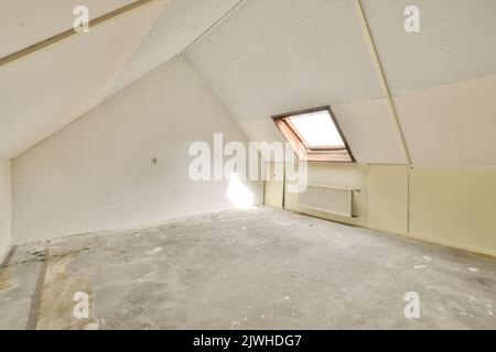 Una camera vuota accogliente e spaziosa in stile mansarda Foto Stock