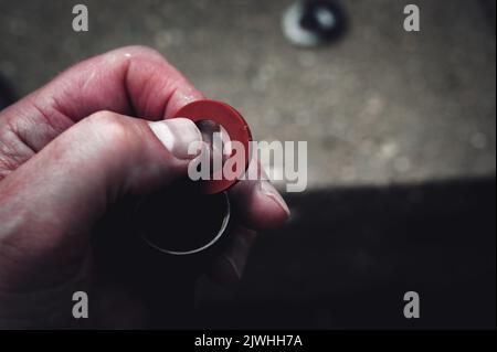 La nuova guarnizione in gomma viene sostituita in un raccordo femmina per tubo da giardino per avere un raccordo a tenuta stagna. Foto Stock