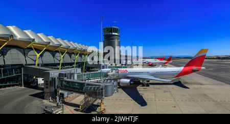 Madrid, Spagna - 28 giugno 2021: Architettura moderna di un terminal a Madrid International Airport, Aeropuerto Madrid Barajas, MAD e un aereo Iberia Foto Stock