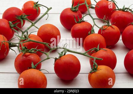 Pomodori ciliegini freschi isolati su sfondo di legno chiaro. Primo piano Foto Stock
