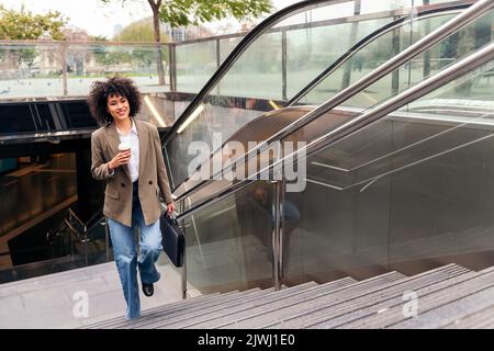 donna d'affari che lascia la stazione della metropolitana Foto Stock