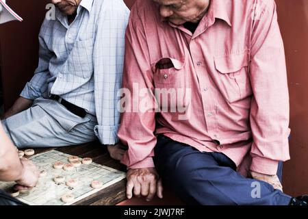 Uomini vietnamiti che giocano una partita di cờ tướng (alias Xiangqi, o scacchi cinesi) a Cabramatta — Sydney, Australia Foto Stock