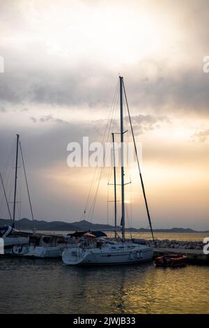 Piccolo porto con yacht e barche a vela nel villaggio di Bibinje al tramonto in Croazia Foto Stock