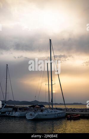 Piccolo porto con yacht e barche a vela nel villaggio di Bibinje al tramonto in Croazia Foto Stock