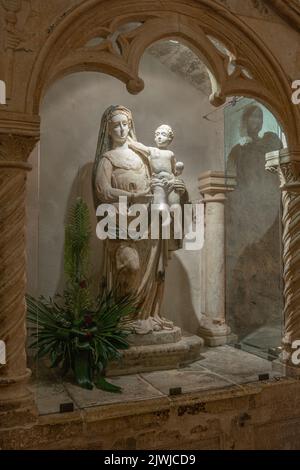 La statua della Vergine Maria con il bambino in braccio lungo la scala interna che conduce alla grotta di San Michele. Monte Sant'Angelo, Puglia Foto Stock